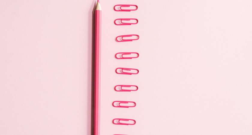 pink pencil near paper clips